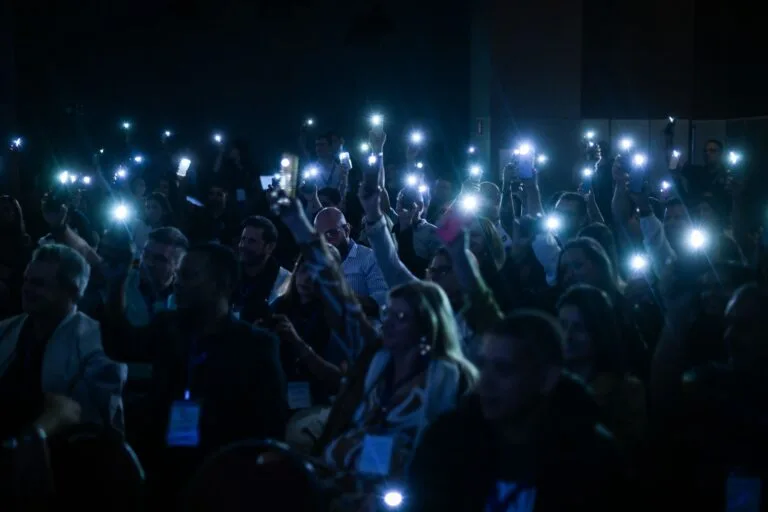 Plateia com as lanternas dos celulares acesas durante a palestra