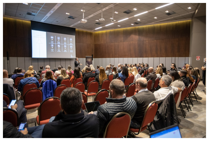 Treinamento corporativo com plateia cheia em auditório de madeira