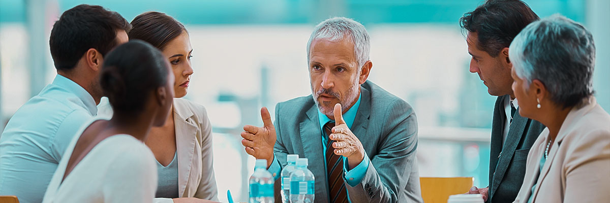 Imagem mostra pessoas em reunião em uma sala de alguma empresa