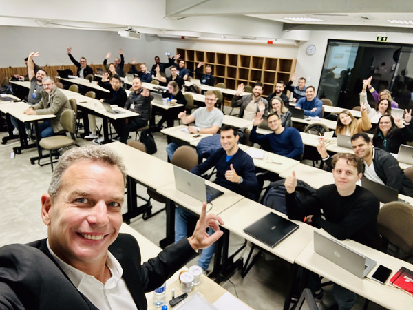 Professor Alfredo Bravo em uma foto estilo selfie, sorrindo, mostrando a turma em sala de aula.
